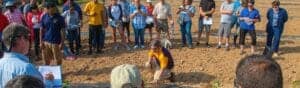 Planting tree with group of volunteers outdoors for environmental conservation.