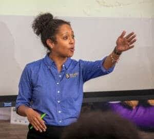 A woman in a blue NC A&T State University shirt giving a presentation or lecture.
