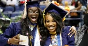 Graduates celebrating at a graduation ceremony in caps and gowns.