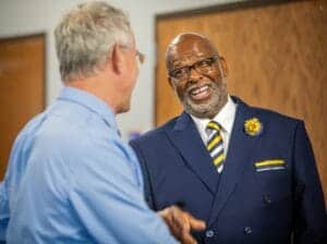 A1. ALT tag: Professional handshake between two men in business attire at a conference.