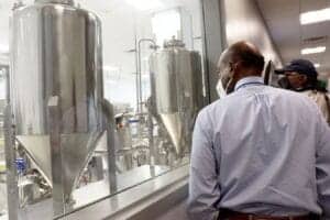 Industrial manufacturing process with stainless steel equipment and workers.