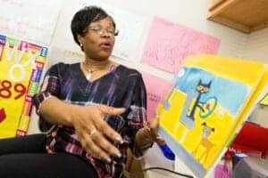 Woman reading a colorful children's book at CAES News office.