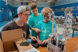LEGO robotics workshop with children and instructor in classroom setting.