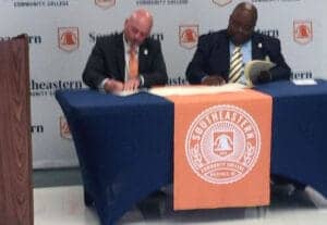 An image of two men signing documents at a table with Southeastern Community College branding.