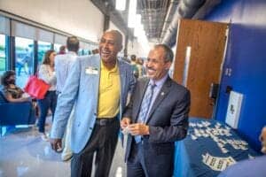 Business professionals smiling at networking event in modern office space.
