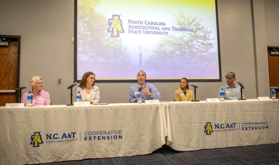 North Carolina A&T State University logo displayed on a presentation screen at a panel discussion.