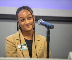 Empowered woman speaking at conference on leadership and diversity in the workplace.