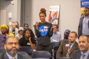 Innovative woman asking questions at a conference on space exploration and NASA.