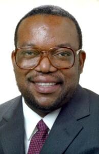 Innovative African Business Leader in Formal Suit and Glasses.