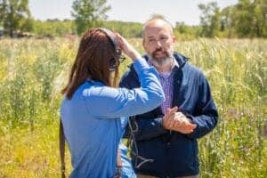 Environmental scientist conducting field research in a grassy outdoor area.
