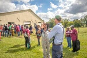 Crowd gathering outdoors at a community event, engaging in conversations and networking on a sunny d.