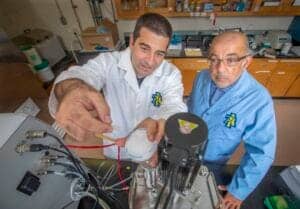 Scientists working with biomedical equipment in a laboratory setting.