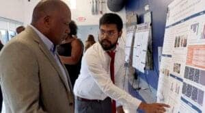 Researchers discussing scientific posters at a conference or academic event.