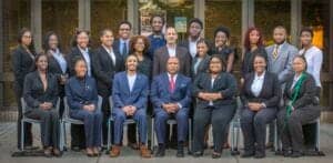 Diverse professional team of businesspeople posing outdoors for a group photo.