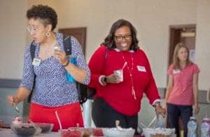 Healthy women enjoying a social event with food and drinks at a conference or gathering.