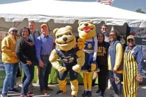 CAES News mascot and staff at outdoor event promoting community engagement and school spirit.