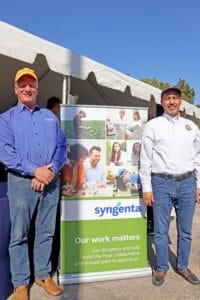 Engaging outdoor event featuring Syngenta representatives promoting agricultural collaboration.
