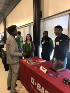 Students and recruiters engaging at CAES career fair booth with D-BAS branding.