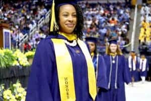 Graduation graduate in cap and gown at commencement ceremony, celebrating academic achievement.