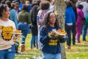 Students enjoying outdoor event with food at CAES News gathering.