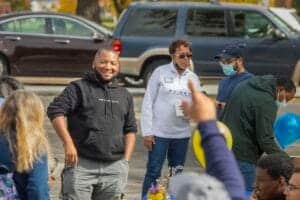 Community gathering with diverse individuals outdoors, promoting social engagement and local news co.
