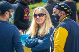 Accessible, diverse group of people engaging in outdoor conversation at a community event.