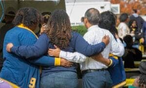 Celebration of unity and diversity at a community event with people embracing each other.