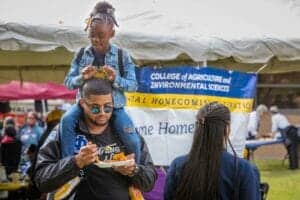 Vibrant college fair at outdoor event showcasing students and educational booths.