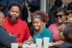 Celebrating community and diversity at a social gathering with smiling individuals enjoying food and.