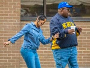 Enjoying a casual moment outside a brick building with friends, showcasing diversity and friendship.