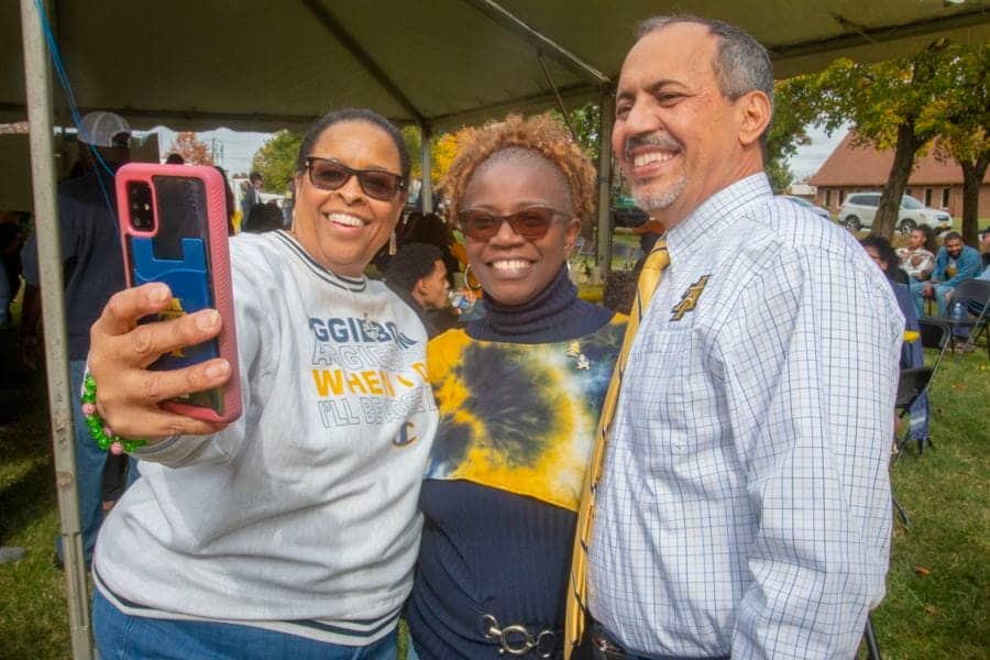 Celebrating community at CAES News event with diverse smiling attendees outdoors.