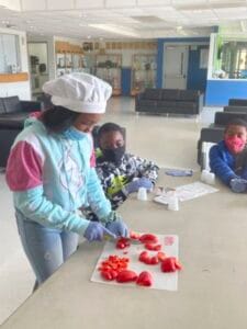 Woman preparing sliced strawberries at CAES News in a bright, modern setting.
