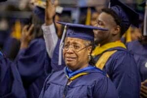 Graduation ceremony with diverse students in caps and gowns celebrating academic achievement.