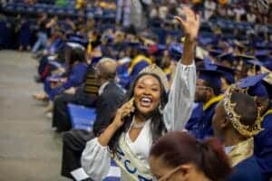 Celebrating graduation at CAES News with joyful students in caps and gowns.