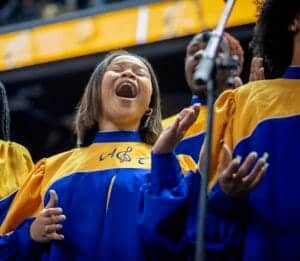 Celebrating a joyful choir performance with children in yellow and blue robes at a school event.