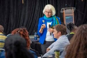 Empowered woman speaker engaging diverse audience at a conference or seminar.