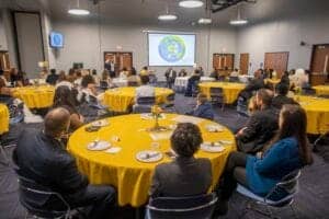 Engaged audience attending a conference in a spacious meeting room with a presentation screen.