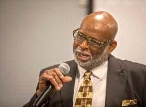 Engaged senior man speaking into microphone at conference or event.