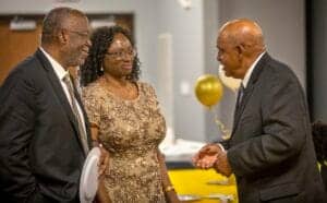 Engaged professionals in formal attire having a conversation at a networking event.