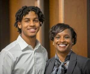 Senior African American man and woman smiling, dressed in professional attire, in an office setting.
