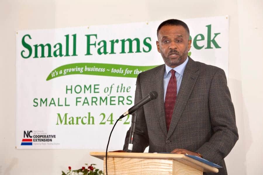 Small Farms Week event speaker at a podium with banner in background.