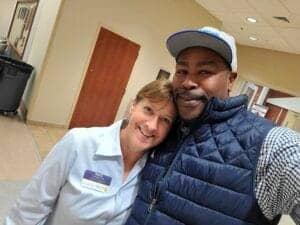 Healthcare workers smiling for a selfie in a hospital or clinic setting.