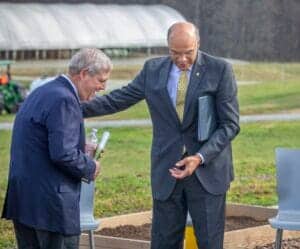 Two businessmen in suits having a respectful conversation outdoors.