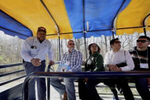 Diverse group of people enjoying a ride on an outdoor amusement park attraction.