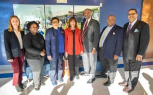 Diverse group of professionals standing together at a conference or event in a modern building.
