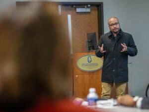 An expert speaker presenting at a conference or seminar in a professional setting.