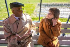 Talking elderly couple sitting on a park bench, engaged in conversation outdoors.