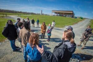 Group of people gathered outdoors near a modern building on a sunny day.