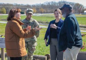Community leaders and military personnel discussing outdoor project plans.