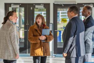 Engaged business professionals having a conversation at an office entrance.